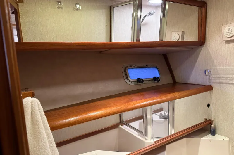 Slide: The Image of 1985 Bayliner 4550 Motoryacht bathroom with sink, toilet, and mirror. - 49