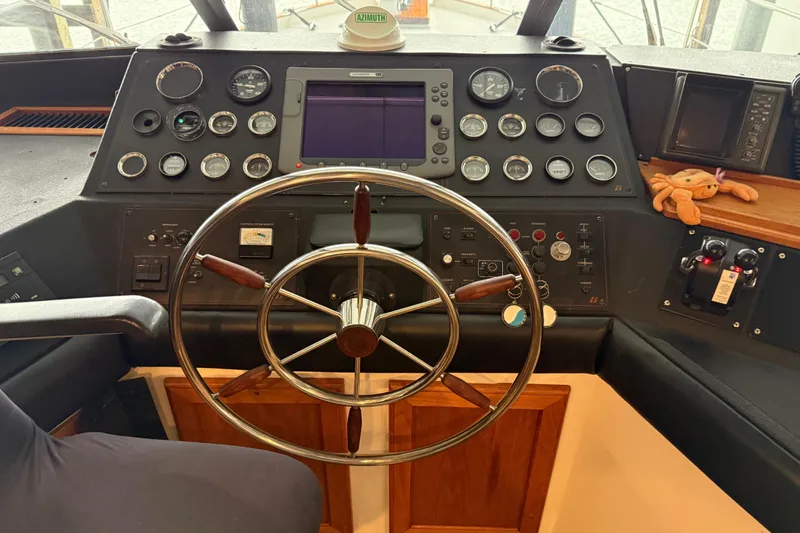 Slide: The Image of 1985 Bayliner 4550 Motoryacht helm with steering wheel, controls, and panoramic windows. - 69