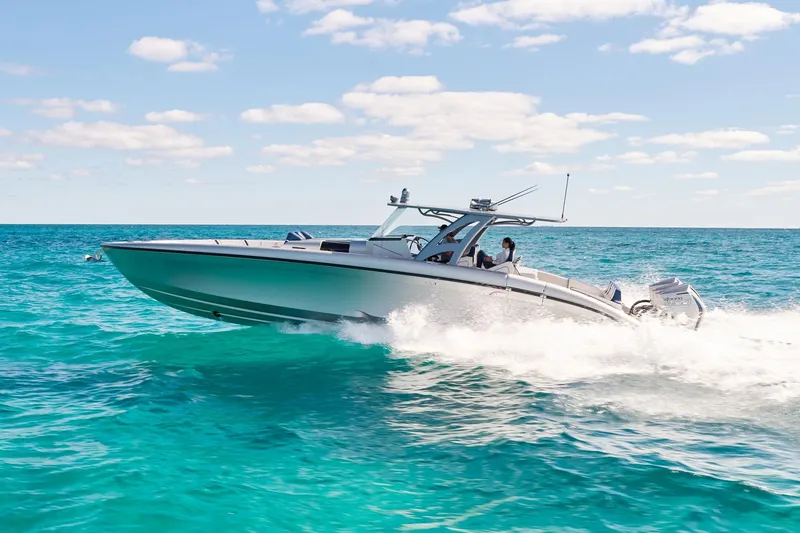 The Image of Midnight Express 43' Solstice boat cruising on clear blue ocean under sunny sky. - 0