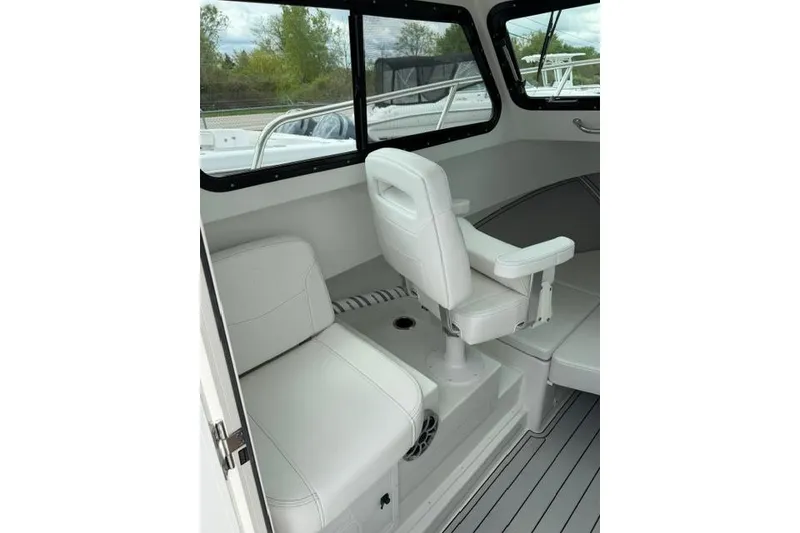 Slide: The Image of Interior of 2026 Parker 227 Explorer boat with white seating and windows. - 14