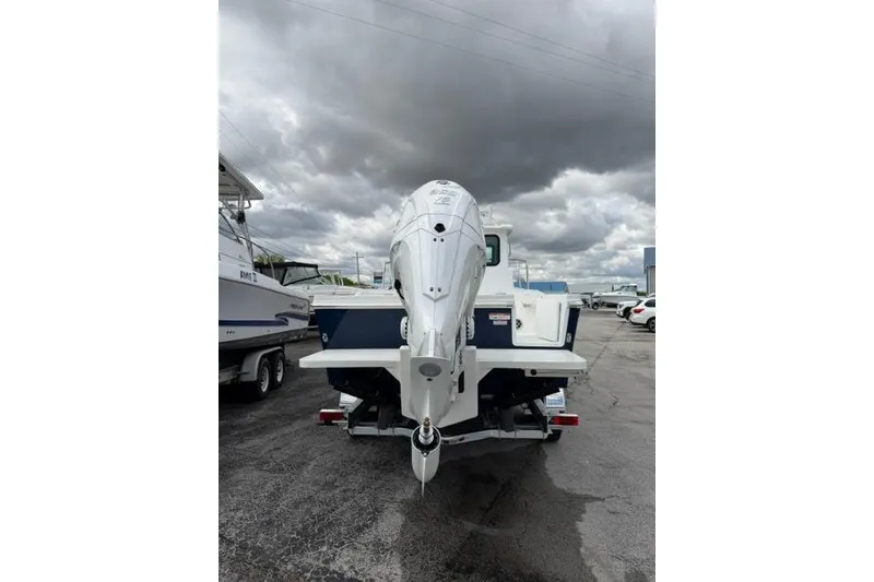 Slide: The Image of 2026 Parker 227 Explorer boat with outboard motor under cloudy sky. - 24