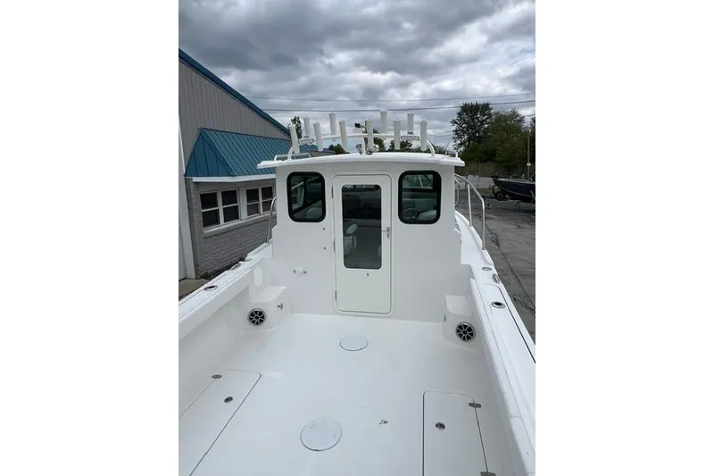 Slide: The Image of 2026 Parker 247 Explorer boat with spacious deck and cabin under cloudy sky. - 17