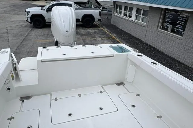 Slide: The Image of 2026 Parker 247 Explorer boat deck with motor, parked near a white truck. - 18