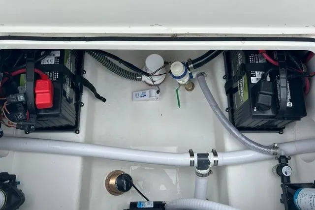 Slide: The Image of Battery compartment of 2026 Parker 247 Explorer boat with wiring and hoses. - 19
