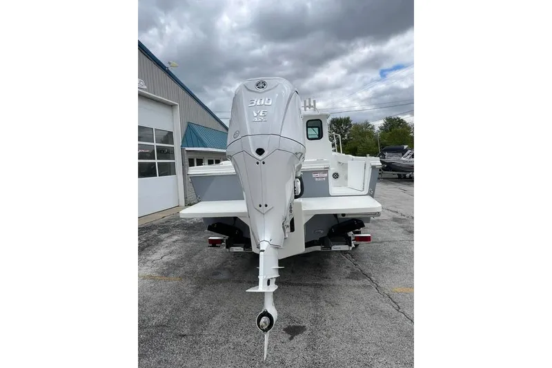 Slide: The Image of 2026 Parker 247 Explorer boat with Yamaha 300 V6 engine, parked outdoors. - 21