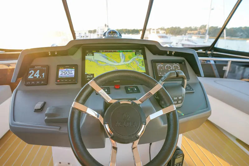 Slide: The Image of Helm of 2021 Aquila 44 Yacht with navigation displays and steering wheel. - 44