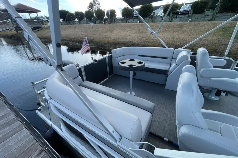 Slide: The Image of 2023 Godfrey Sweetwater 2086 SB pontoon boat interior with seating and table by the water. - 5