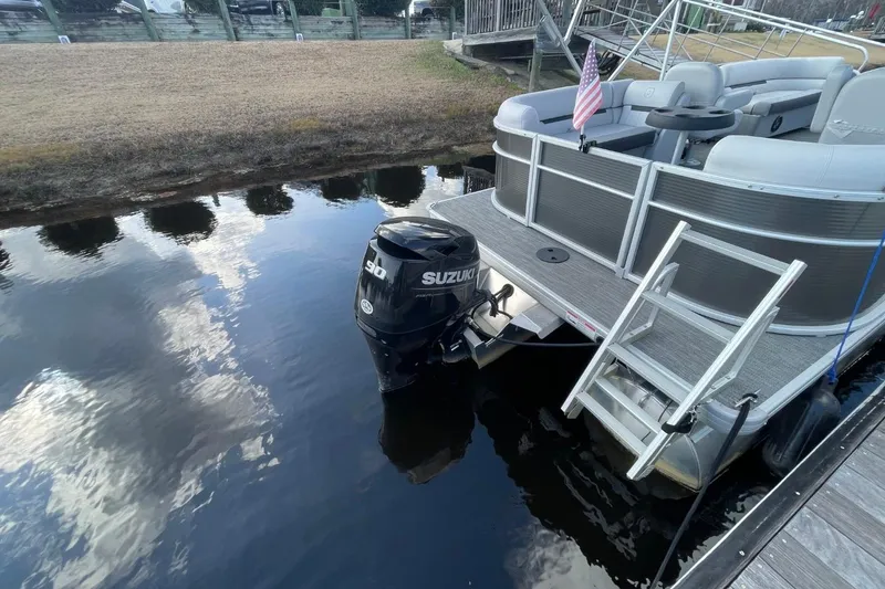 Slide: The Image of 2023 Godfrey Sweetwater 2086 SB pontoon boat with Suzuki outboard motor on calm water. - 6