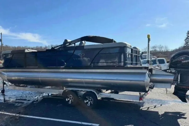 Slide: The Image of 2025 Veranda Relax VR25RC pontoon boat on trailer under clear blue sky. - 3