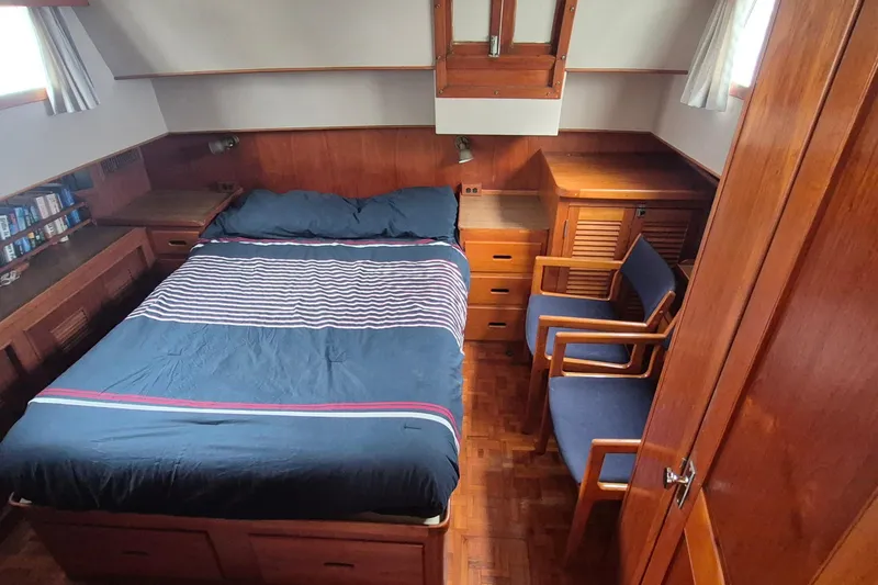 Slide: The Image of Cozy bedroom in 1983 Grand Banks 42 Classic yacht with wood paneling and striped bedding. - 14