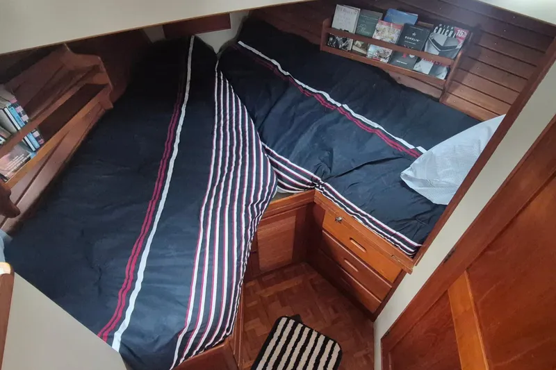 Slide: The Image of Cozy cabin bedroom in 1983 Grand Banks 42 Classic yacht with striped bedding and wooden storage. - 18