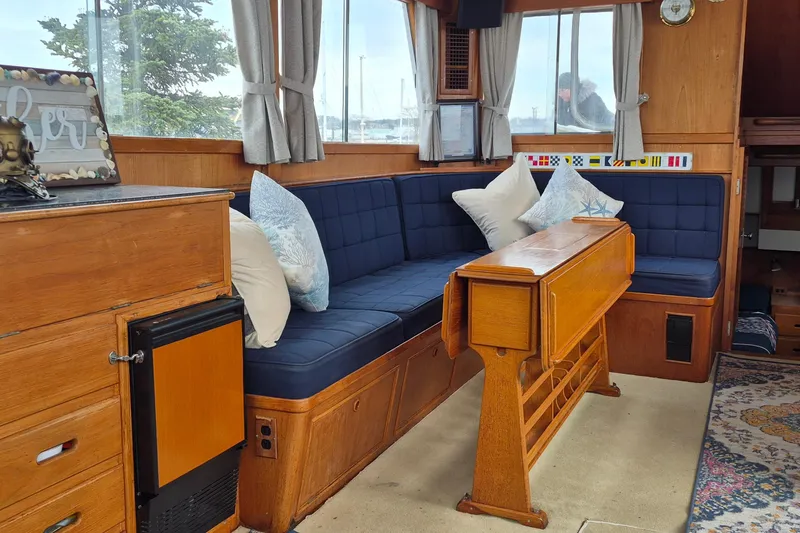 Slide: The Image of Interior of 1983 Grand Banks 42 Classic yacht with wooden furnishings and blue cushions. - 4