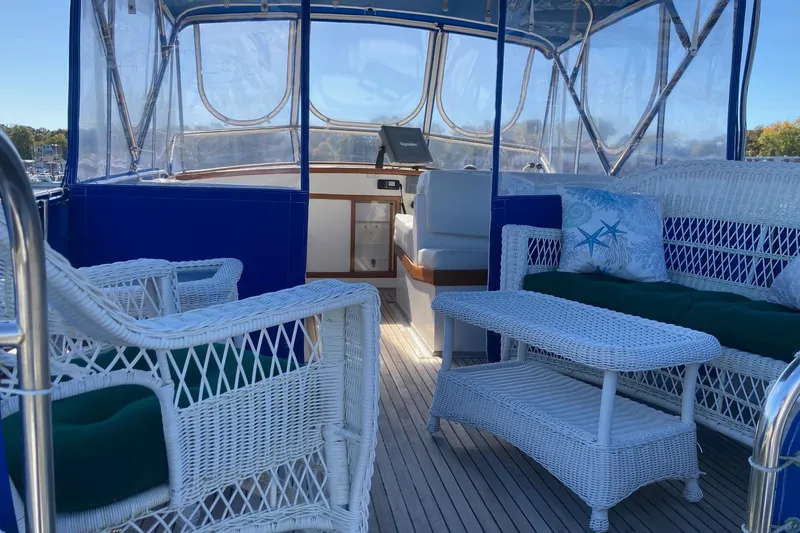 Slide: The Image of 1983 Grand Banks 42 Classic yacht with wicker seating on deck, docked at a boatyard. - 40