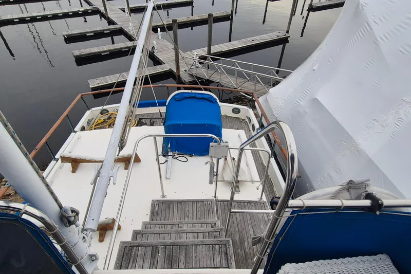 Slide: The Image of 1983 Grand Banks 42 Classic yacht deck with wooden steps and blue cover. - 46