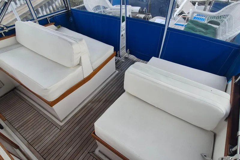 Slide: The Image of 1983 Grand Banks 42 Classic yacht deck with wooden steps and blue seating. - 48