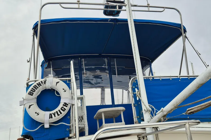 Slide: The Image of Interior seating of 1983 Grand Banks 42 Classic yacht with white cushions and wooden flooring. - 49