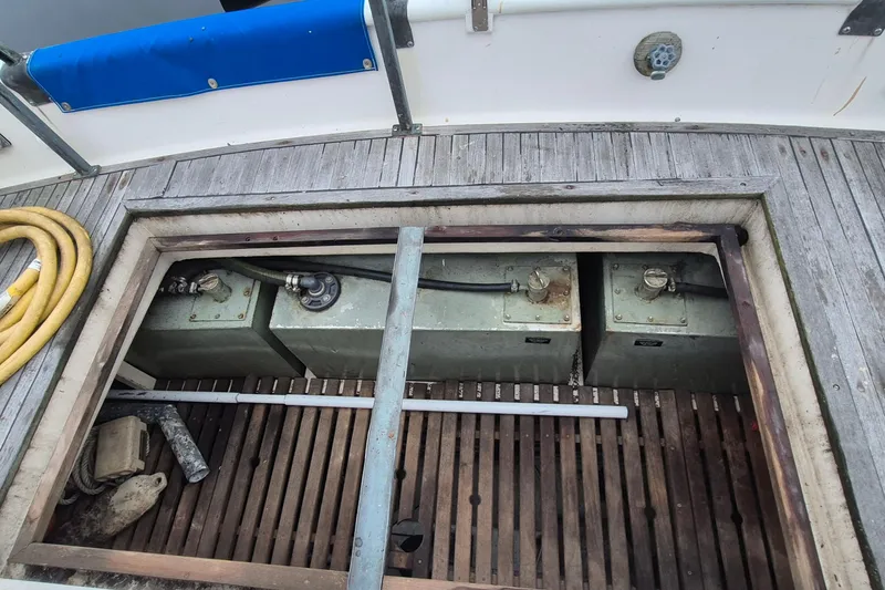 Slide: The Image of 1983 Grand Banks 42 Classic deck with weathered wood and coiled yellow hose. - 56