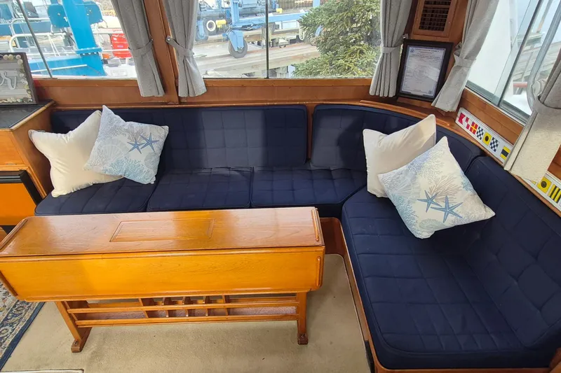 Slide: The Image of Interior of 1983 Grand Banks 42 Classic with navy seating and decorative pillows. - 7