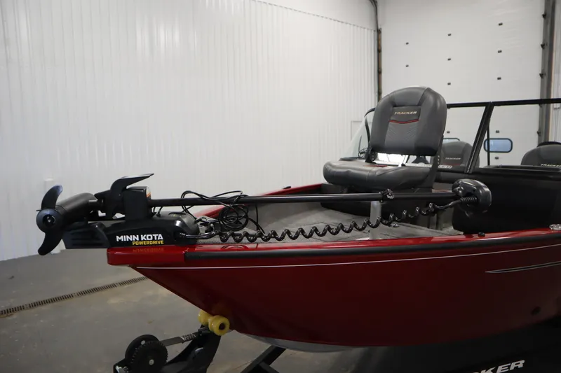 Slide: The Image of 2024 Tracker Pro Guide V-16 WT boat with Minn Kota PowerDrive motor in a garage. - 11