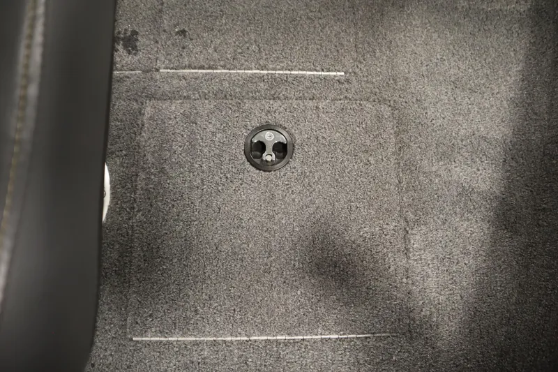 Slide: The Image of Carpeted floor of 2024 Tracker Pro Guide V-16 WT boat with a circular fixture. - 18