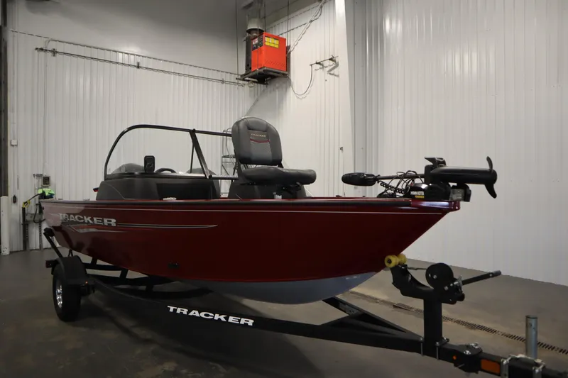 Slide: The Image of 2024 Tracker Pro Guide V-16 WT boat in a garage, red exterior, on a trailer. - 3