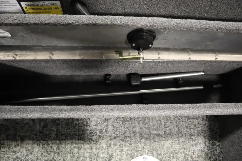 Slide: The Image of 2024 Tracker Pro Guide V-16 WT storage compartment with rods and capacity label. - 36
