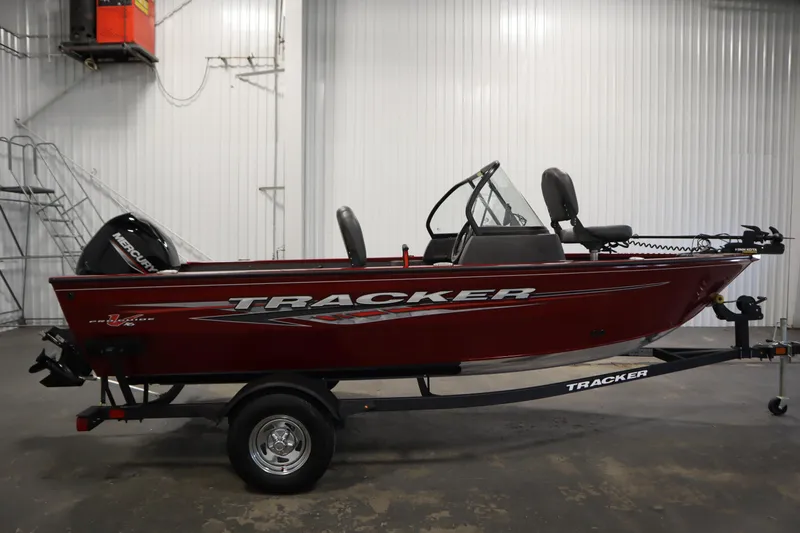 Slide: The Image of 2024 Tracker Pro Guide V-16 WT boat in a showroom, side view. - 4