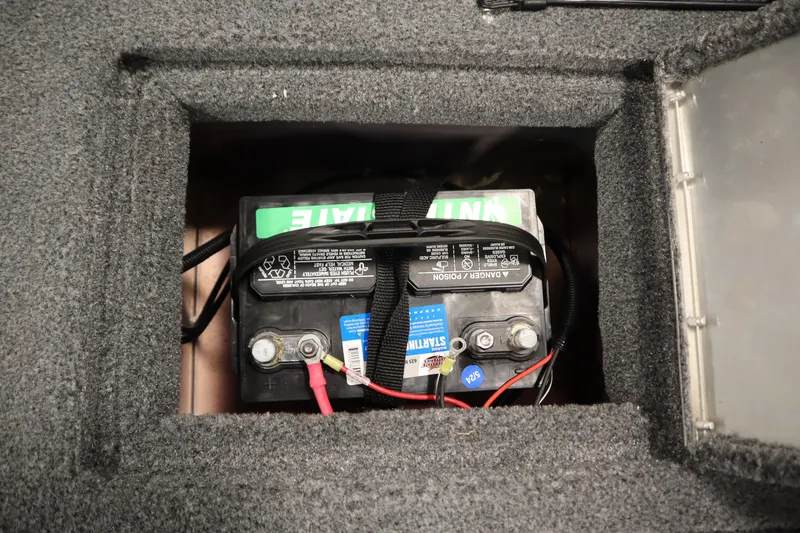 Slide: The Image of Battery compartment of 2024 Tracker Pro Guide V-16 WT boat, featuring a secured battery. - 41