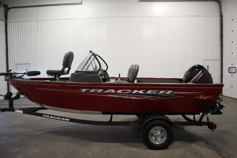 Slide: The Image of 2024 Tracker Pro Guide V-16 WT boat in a garage, side view. - 8