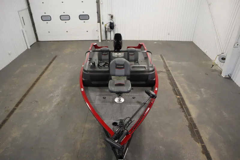 Slide: The Image of 2024 Tracker Pro Guide V-16 WT boat in a garage, featuring a red exterior and fishing seat. - 9