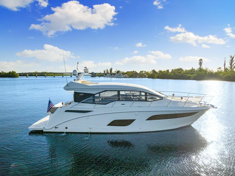 Slide: The Image of 2017 Sea Ray 460 Sundancer yacht on calm water under a clear blue sky. - 10