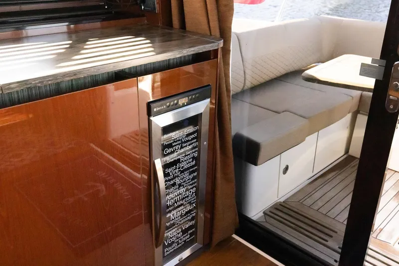 Slide: The Image of Interior of 2017 Sea Ray 460 Sundancer yacht, featuring a compact kitchen and cozy seating area. - 42