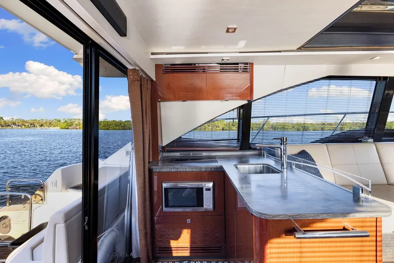 Slide: The Image of Luxurious 2017 Sea Ray 460 Sundancer yacht interior with modern kitchen and scenic water view. - 49