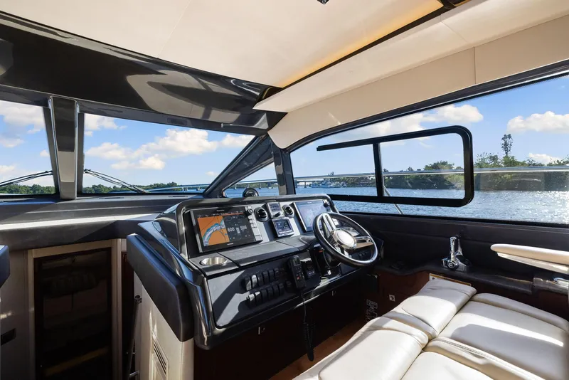 Slide: The Image of Interior view of 2017 Sea Ray 460 Sundancer yacht helm with modern controls and panoramic windows. - 72