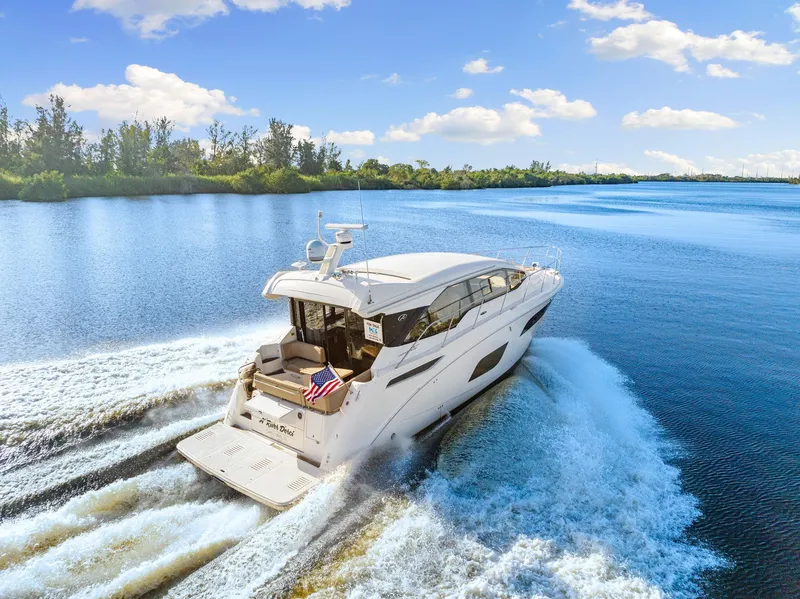 Slide: The Image of 2017 Sea Ray 460 Sundancer cruising on a sunny lake, leaving a wake behind. - 9