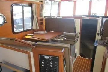 Slide: The Image of 2021 Ranger Tugs R-31 CB interior with seating, table, and wood accents. - 10