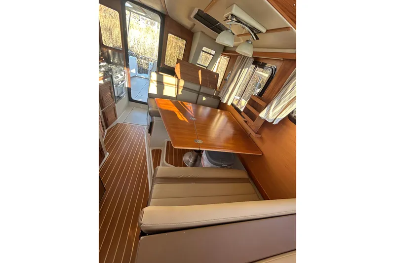Slide: The Image of Interior of 2021 Ranger Tugs R-31 CB with wood accents and seating area. - 12