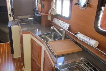 Slide: The Image of 2021 Ranger Tugs R-31 CB interior kitchen with wooden cabinetry and modern appliances. - 13