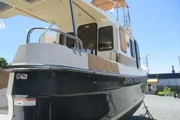 Slide: The Image of 2021 Ranger Tugs R-31 CB boat, docked, side view under clear blue sky. - 3