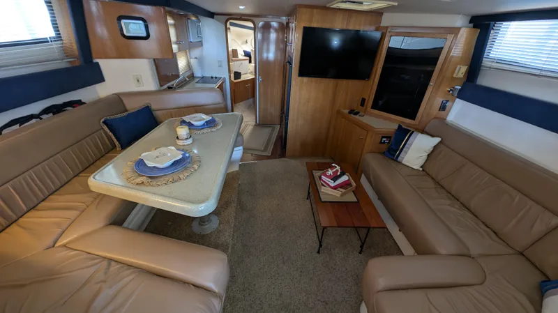 Slide: The Image of Interior of a 2002 Carver 350 Mariner yacht with leather sofas and dining table. - 22