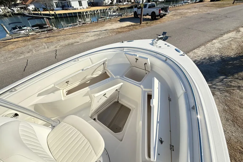 Slide: The Image of 2008 Robalo R240 Center Console boat with open storage compartments, dockside view. - 10