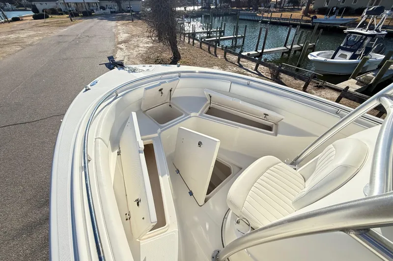 Slide: The Image of 2008 Robalo R240 Center Console boat with open storage compartments docked by the water. - 11