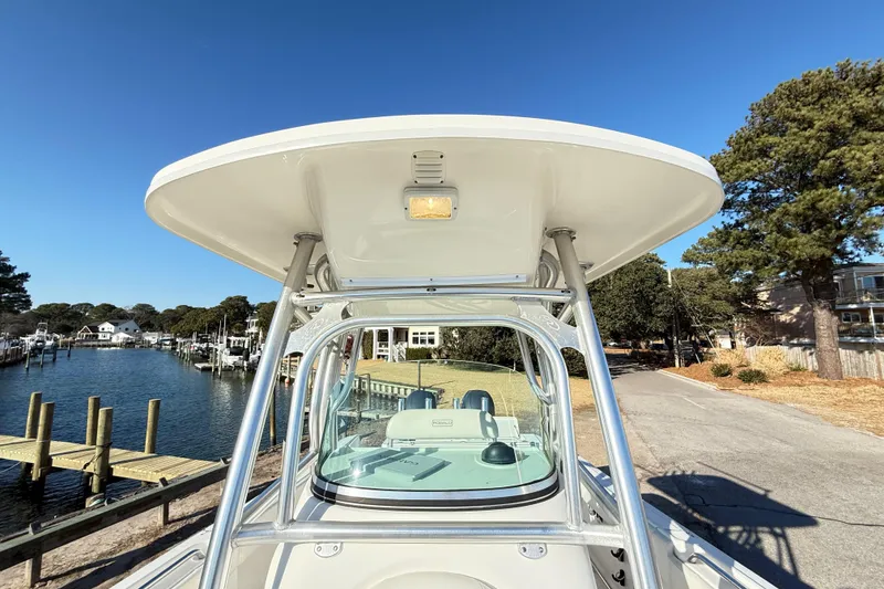 Slide: The Image of 2008 Robalo R240 Center Console boat with T-top, docked near waterfront homes. - 13