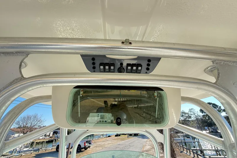 Slide: The Image of 2008 Robalo R240 Center Console boat interior with control panel and overhead storage. - 16