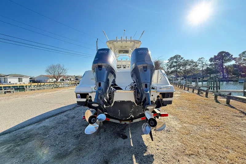 Slide: The Image of 2008 Robalo R240 Center Console boat with dual outboard motors, parked near a waterfront. - 3