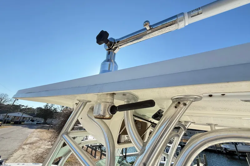 Slide: The Image of 2008 Robalo R240 Center Console boat with T-top and rod holders, docked near water. - 34