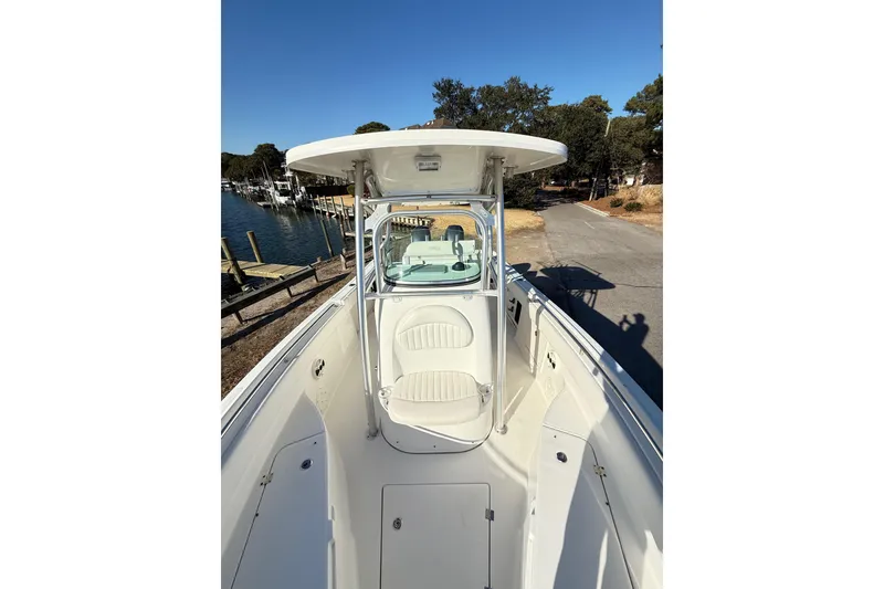 Slide: The Image of 2008 Robalo R240 Center Console boat docked near a marina under clear blue skies. - 43