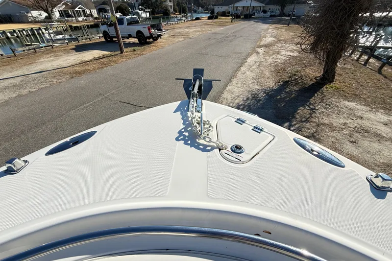Slide: The Image of 2008 Robalo R240 Center Console boat bow with anchor, parked near waterfront homes. - 44