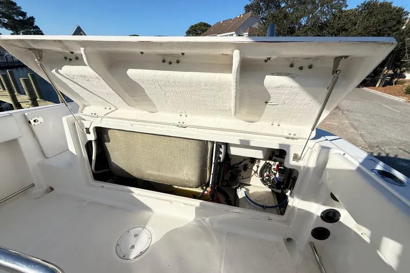 Slide: The Image of 2008 Robalo R240 Center Console boat with open storage compartment, dockside view. - 49