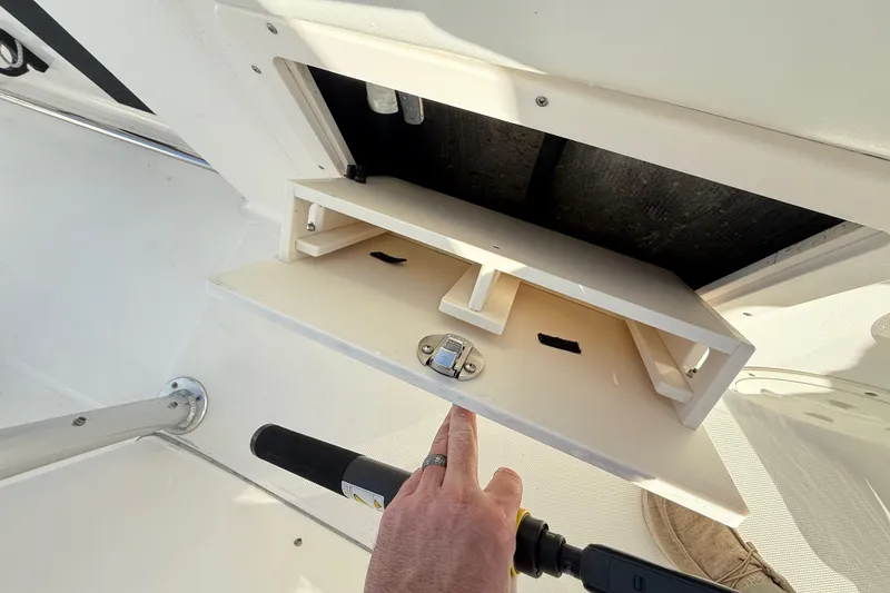 Slide: The Image of Storage compartment on a 2008 Robalo R240 Center Console boat, with open hatch and latch. - 53